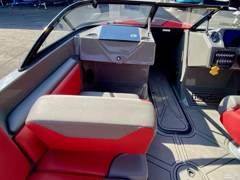 Slide: The Image of 2022 Heyday WTSurf boat interior with red and gray seating, dashboard, and steering wheel. - 9
