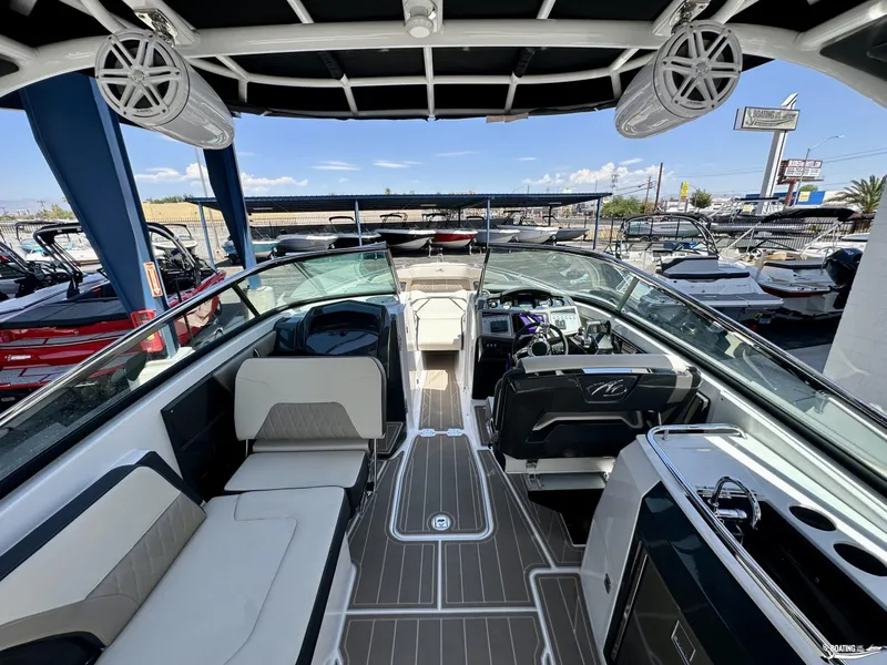 Slide: The Image of 2024 Monterey 305SS boat interior with modern seating and dashboard, displayed at a marina. - 4