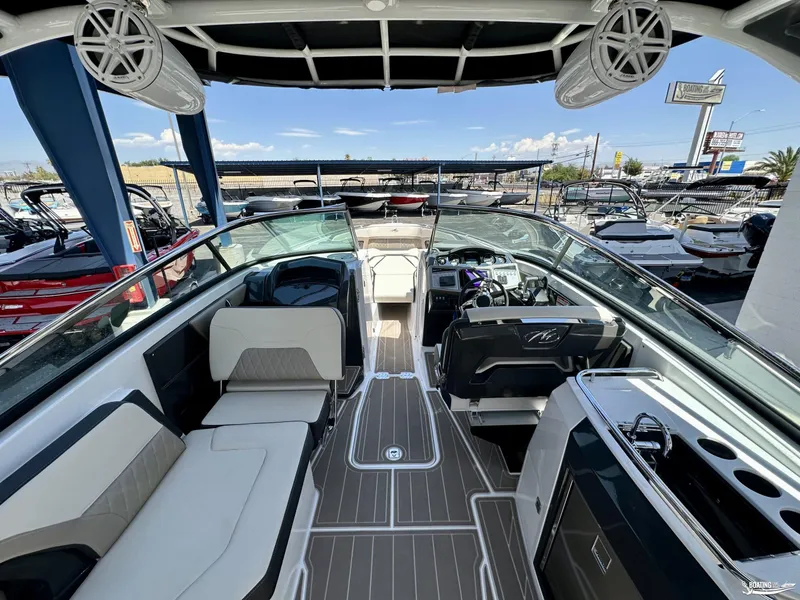 Slide: The Image of 2024 Monterey 305SS boat interior with modern seating and dashboard, docked at marina. - 8