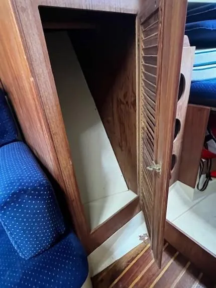 Slide: The Image of 1986 Pearson 303 sailboat interior with open wooden storage compartment. - 14