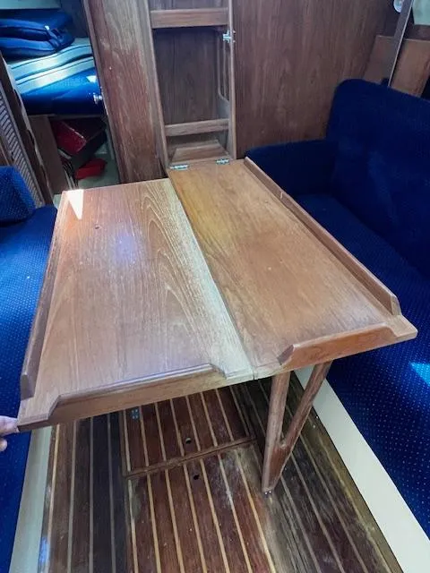 Slide: The Image of Wooden table in 1986 Pearson 303 sailboat interior with blue seating. - 16