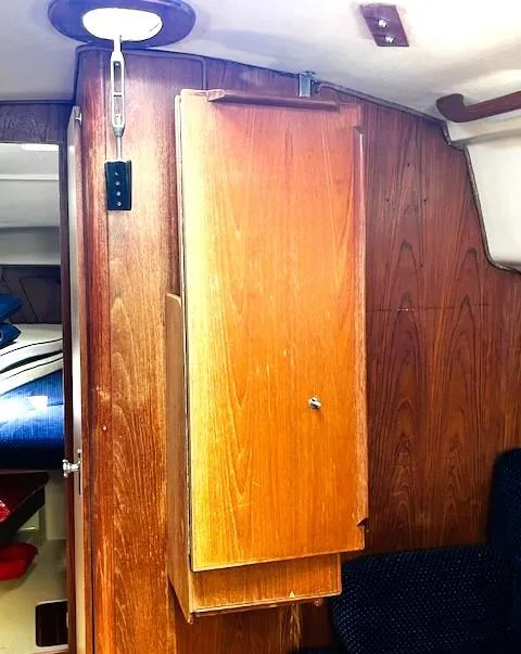 Slide: The Image of Interior of 1986 Pearson 303 sailboat with wooden cabinetry and cozy seating. - 22