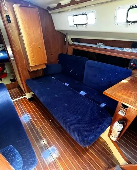 Slide: The Image of Interior of 1986 Pearson 303 sailboat with blue seating and wooden finishes. - 24