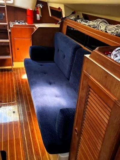 Slide: The Image of 1986 Pearson 303 yacht interior with blue sofa and wooden flooring. - 26