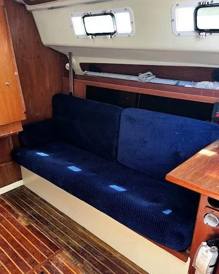 Slide: The Image of Interior of 1986 Pearson 303 sailboat with blue cushioned seating and wooden accents. - 28