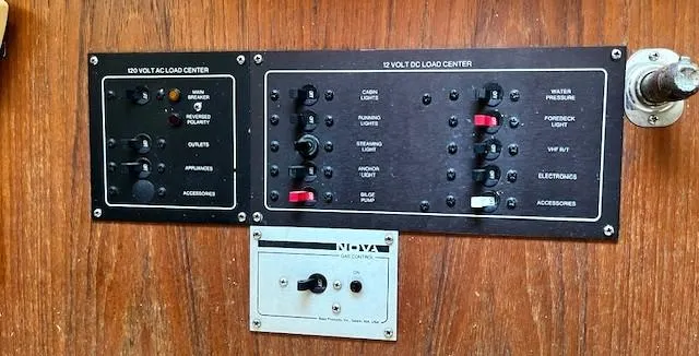 Slide: The Image of Electrical control panel on a 1986 Pearson 303 sailboat, featuring 120V AC and 12V DC load centers. - 30