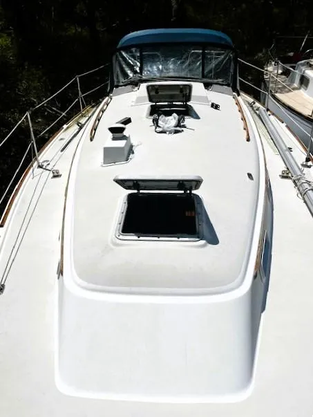 Slide: The Image of 1986 Pearson 303 sailboat deck with open hatches and blue canopy. - 4