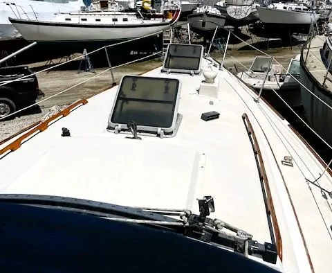 Slide: The Image of 1986 Pearson 303 sailboat on land, showcasing deck and hatches. - 5