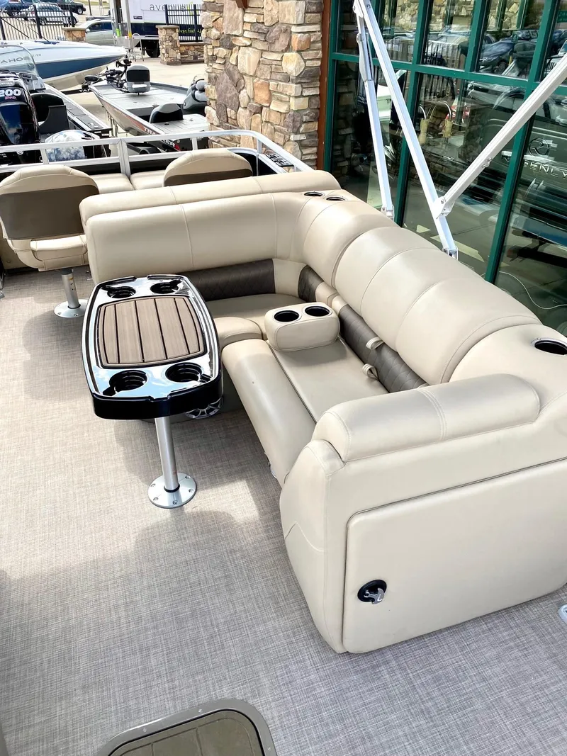 Slide: The Image of 2024 Sun Tracker SportFish 22 XP3 boat interior with beige seating and table. - 5