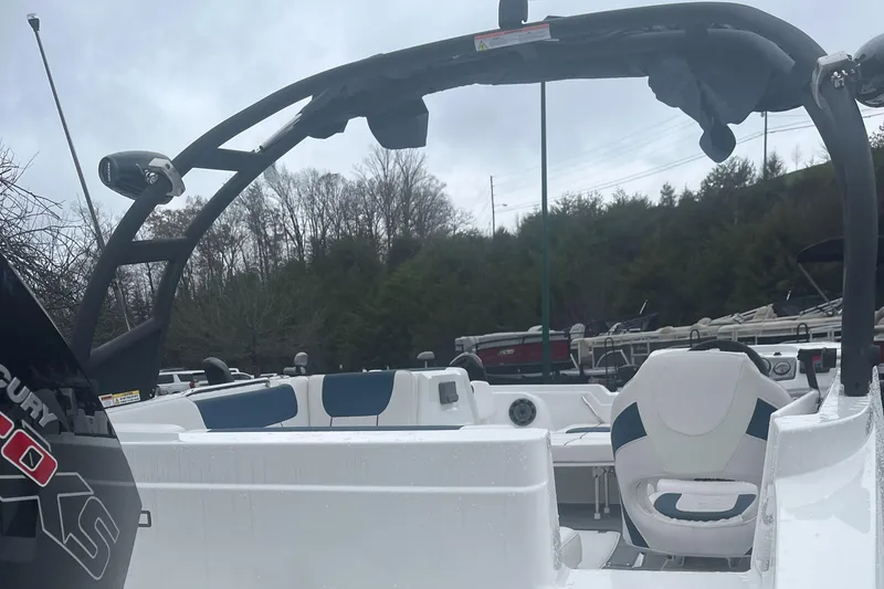 Slide: The Image of 2024 Tahoe 1950 boat interior with seating and steering wheel, overcast sky background. - 1