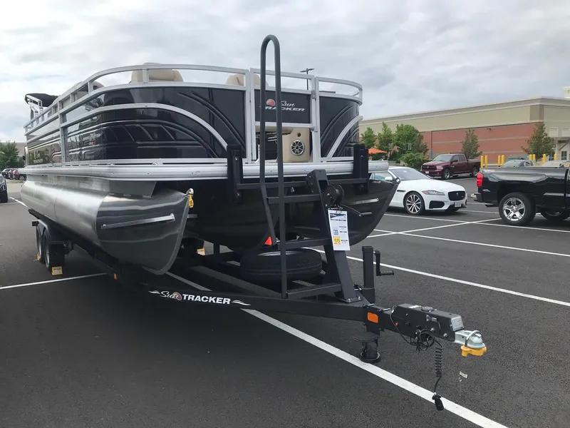 Slide: The Image of 2024 Sun Tracker Sportfish 24 XP3 pontoon boat on a trailer in a parking lot. - 3