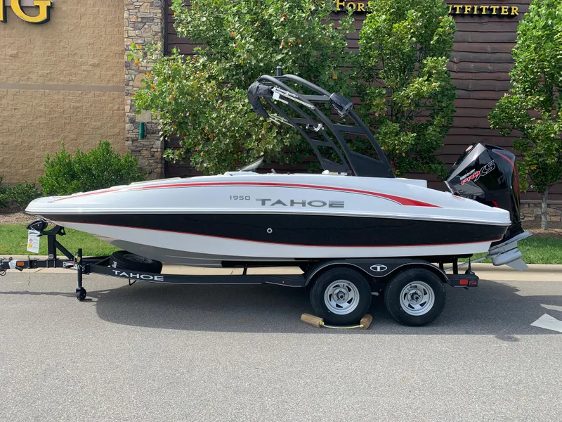 The Image of 2024 Tahoe 1950 boat on trailer, parked outdoors, side view. - 0