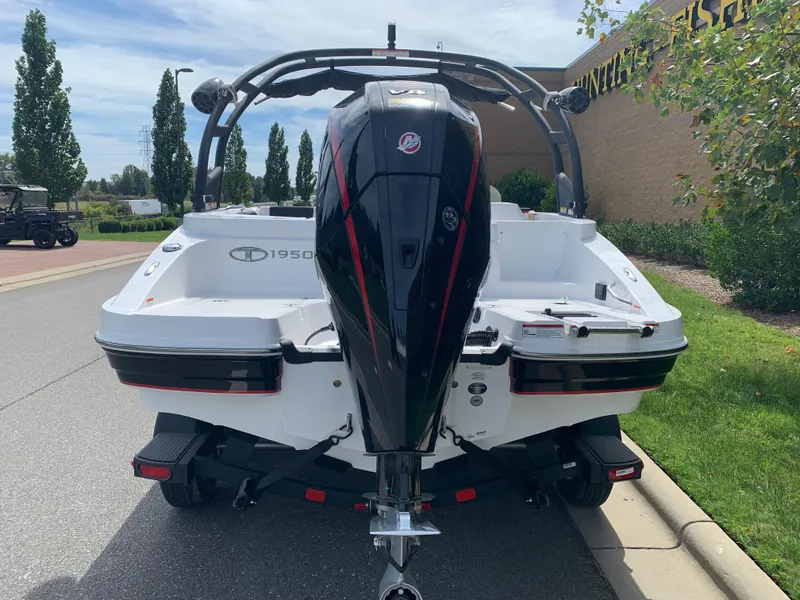 Slide: The Image of 2024 Tahoe 1950 boat with powerful outboard motor, parked on a sunny street. - 2