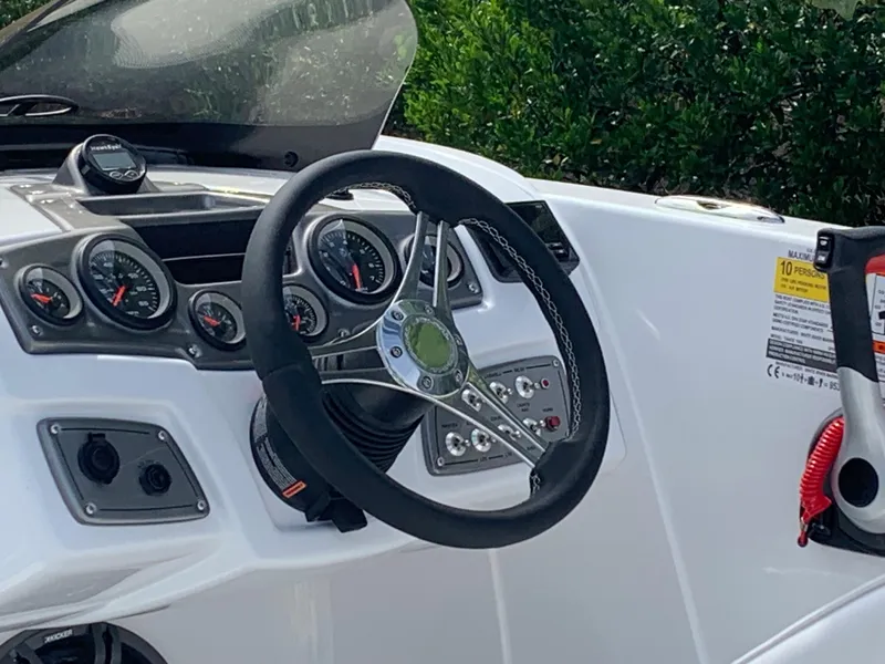 Slide: The Image of 2024 Tahoe 1950 boat dashboard with steering wheel and gauges. - 4