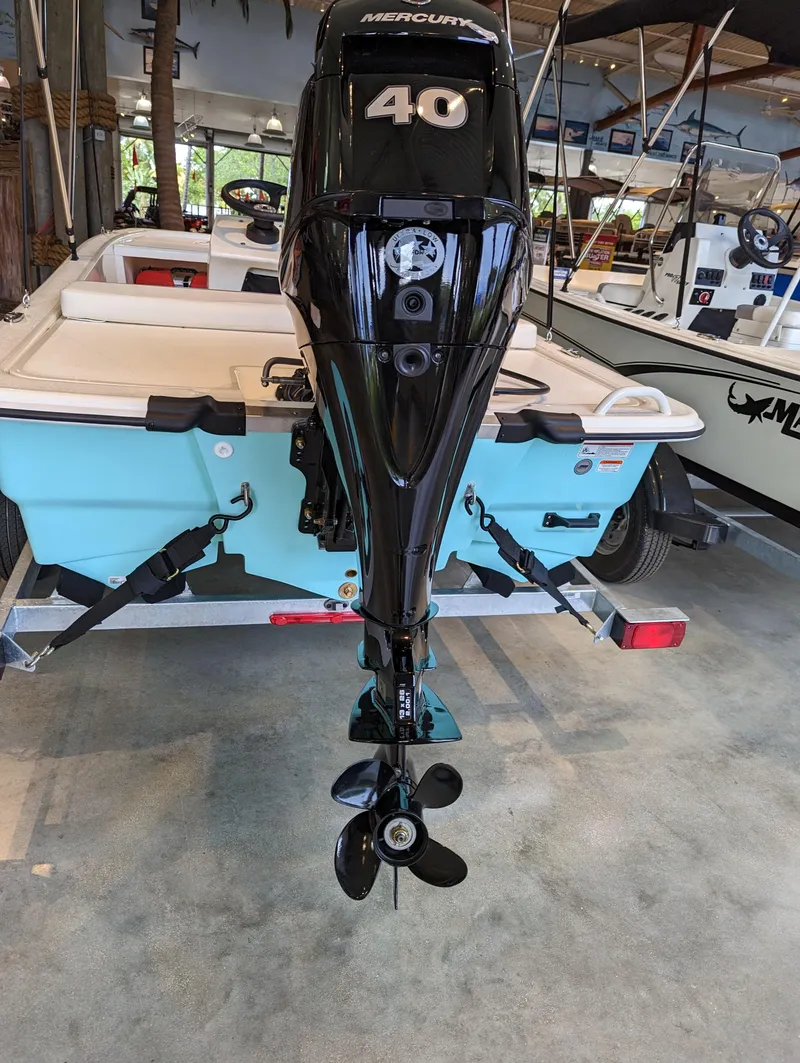 Slide: The Image of 2024 Mako Pro Skiff 13 CC with Mercury 40 HP outboard motor in showroom. - 4