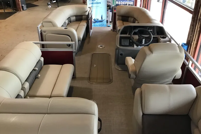 Slide: The Image of 2024 Sun Tracker Party Barge 22 RF XP3 interior with plush seating and steering console. - 2