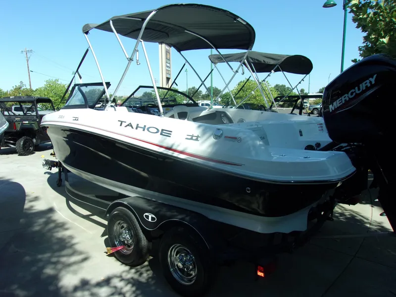 Slide: The Image of 2024 Tahoe 200 S boat on trailer with bimini top and Mercury outboard motor. - 2