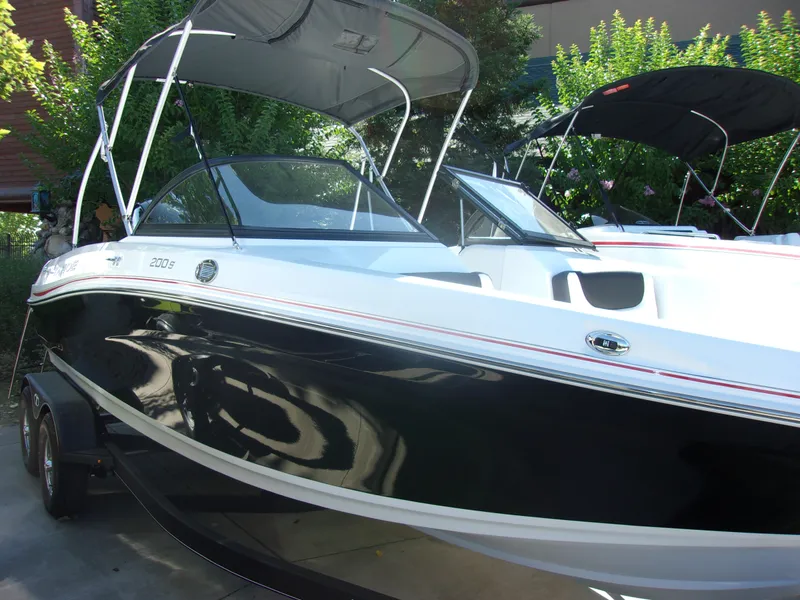 Slide: The Image of 2024 Tahoe 200 S boat with black and white exterior, parked on a trailer. - 3
