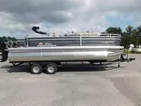 The Image of 2024 Sun Tracker Fishin' Barge 22 XP3 pontoon boat on a trailer. - 0