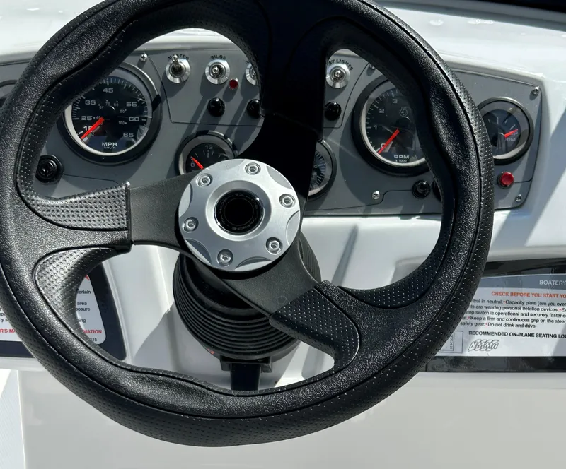 Slide: The Image of Steering wheel and dashboard of 2024 Tahoe 185 S boat with gauges and controls. - 3