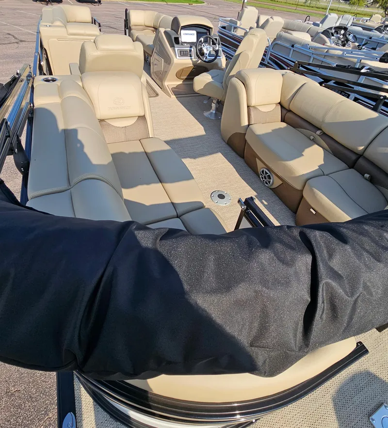 Slide: The Image of 2024 Regency 230 DL3 pontoon boat with luxurious beige seating and modern dashboard. - 11