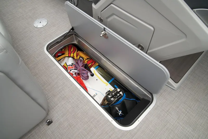 Slide: The Image of 2024 Regency 230 DL3 storage compartment with wakeboard and gear. - 36
