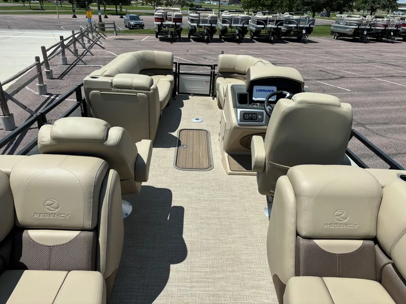 Slide: The Image of 2024 Regency 230 DL3 pontoon boat with beige seating and modern dashboard. - 8
