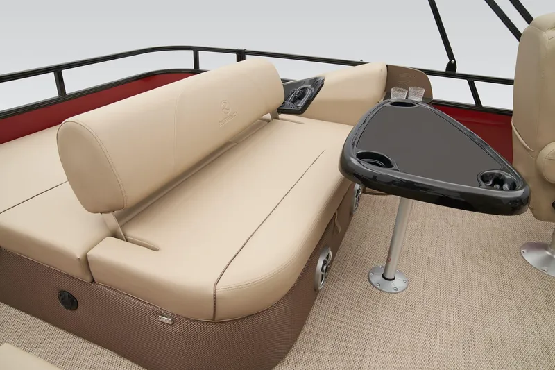 Slide: The Image of 2024 Regency 250 DL3 pontoon boat interior with beige seating and black table. - 35