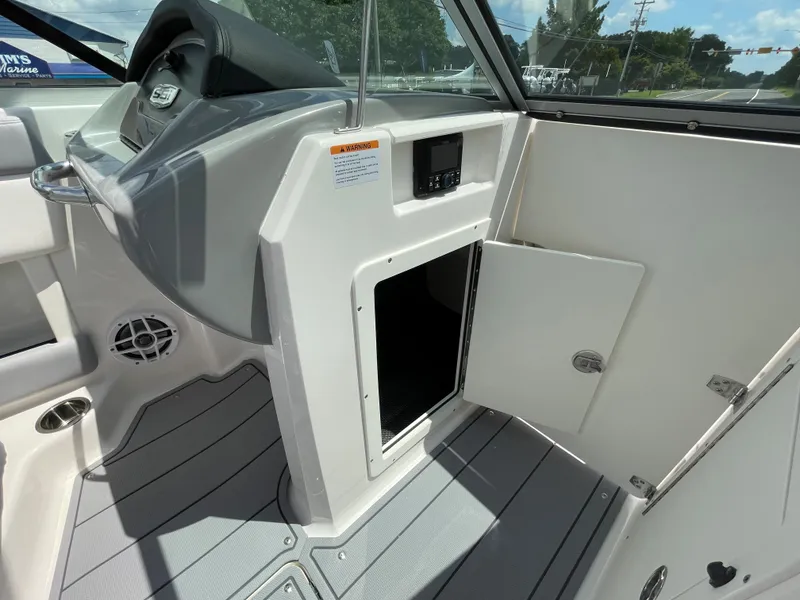 Slide: The Image of 2024 Chaparral 21 SSi OB boat interior storage compartment with open door. - 18
