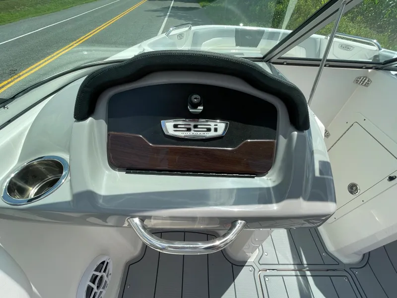 Slide: The Image of 2024 Chaparral 21 SSi OB boat dashboard with cup holder and storage compartment. - 19