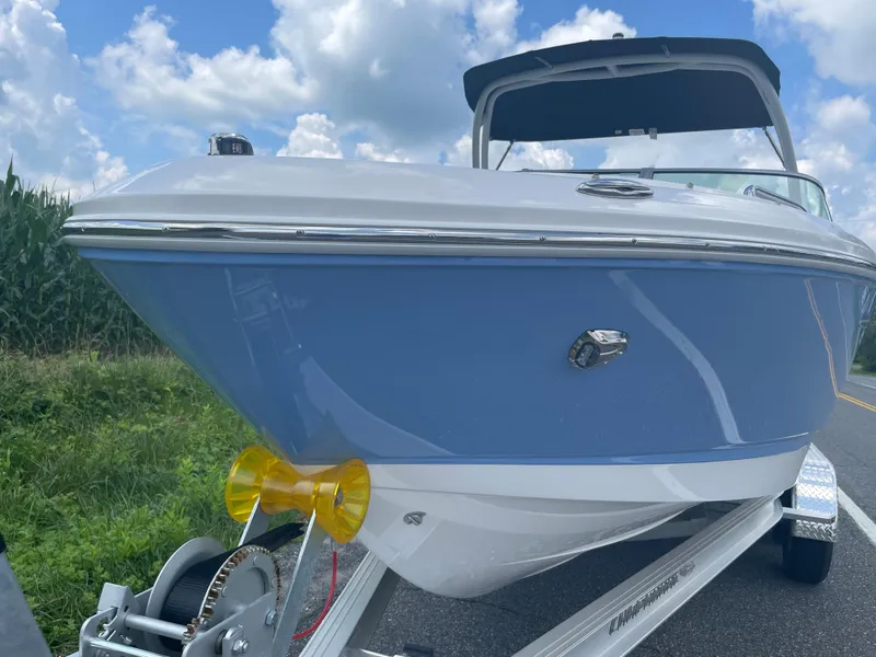 Slide: The Image of 2024 Chaparral 21 SSi OB boat on trailer, blue hull, outdoors. - 2