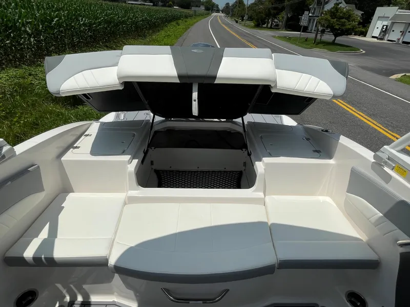 Slide: The Image of 2024 Chaparral 21 SSi OB boat interior with open storage compartments on a road. - 35