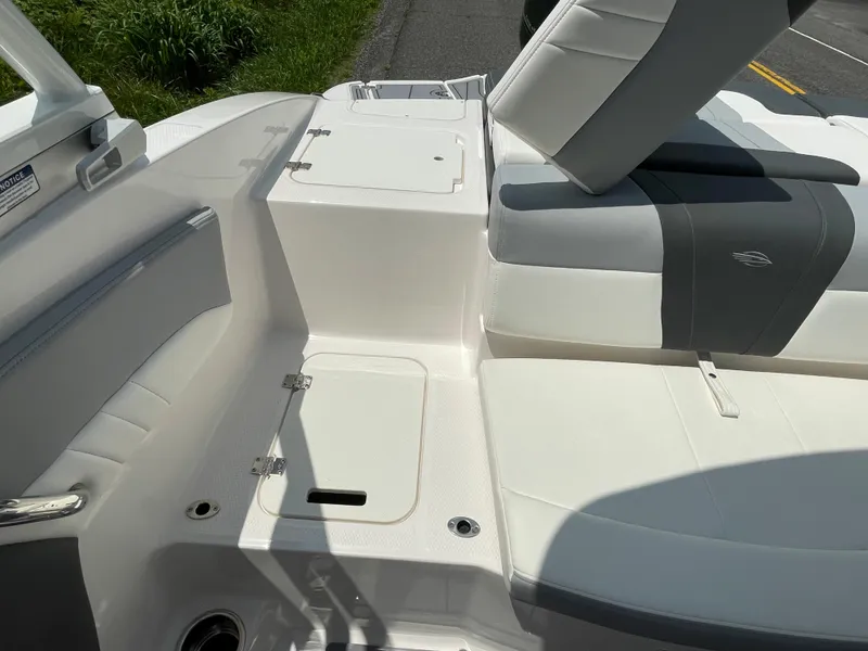 Slide: The Image of 2024 Chaparral 21 SSi OB boat interior, featuring white and gray seating and storage compartments. - 37