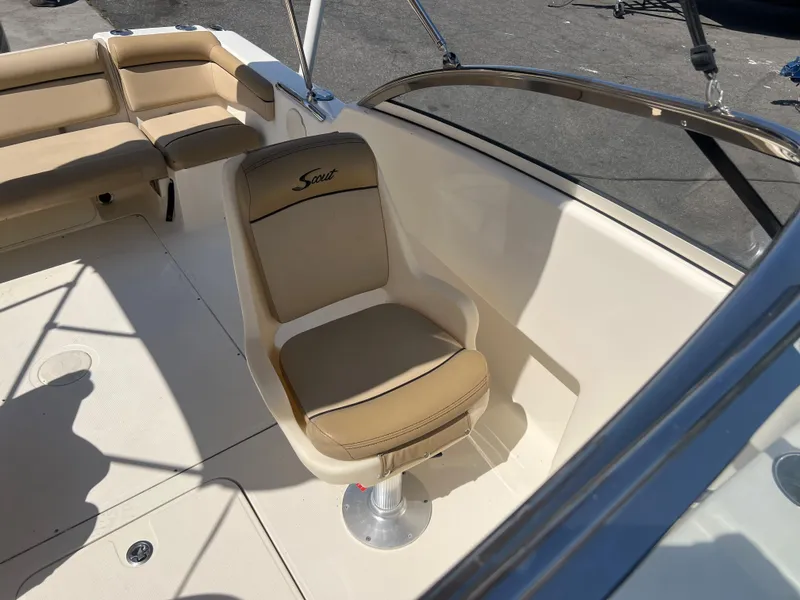 Slide: The Image of 2019 Scout 210 Dorado boat interior with beige seating and steering chair. - 11