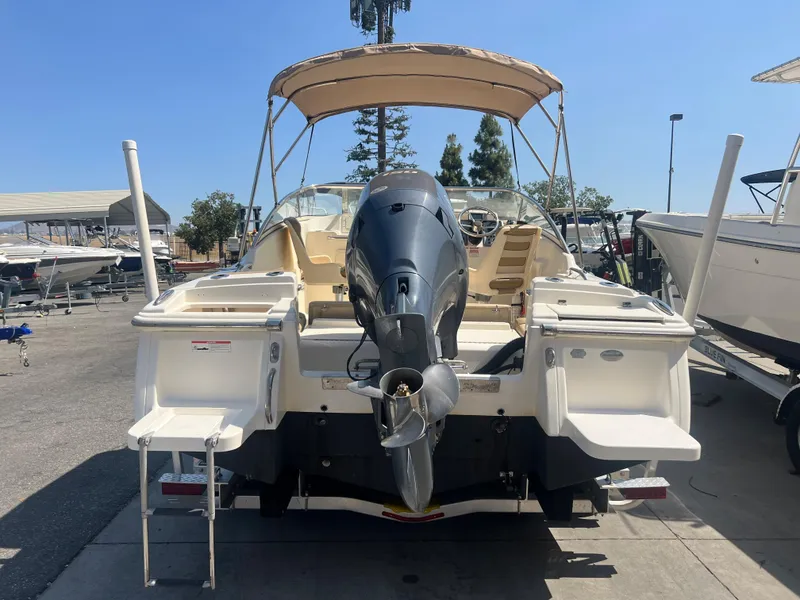 Slide: The Image of 2019 Scout 210 Dorado boat with outboard motor, docked at a marina. - 7