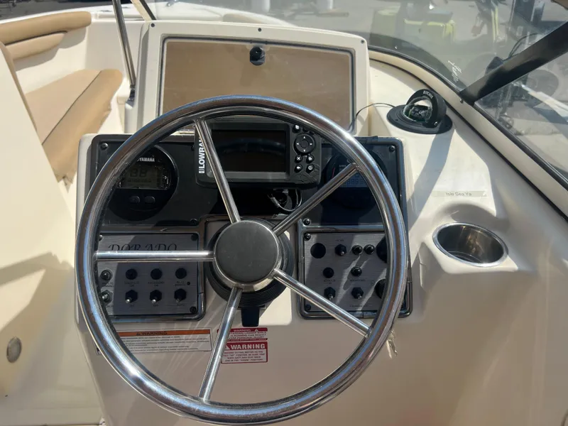 Slide: The Image of 2019 Scout 210 Dorado boat dashboard with steering wheel and control panel. - 8