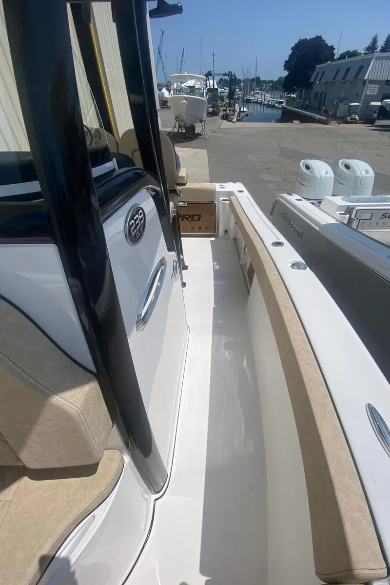 Slide: The Image of 2023 Sea Pro 239 boat docked at a marina, showcasing its sleek design and spacious deck. - 14
