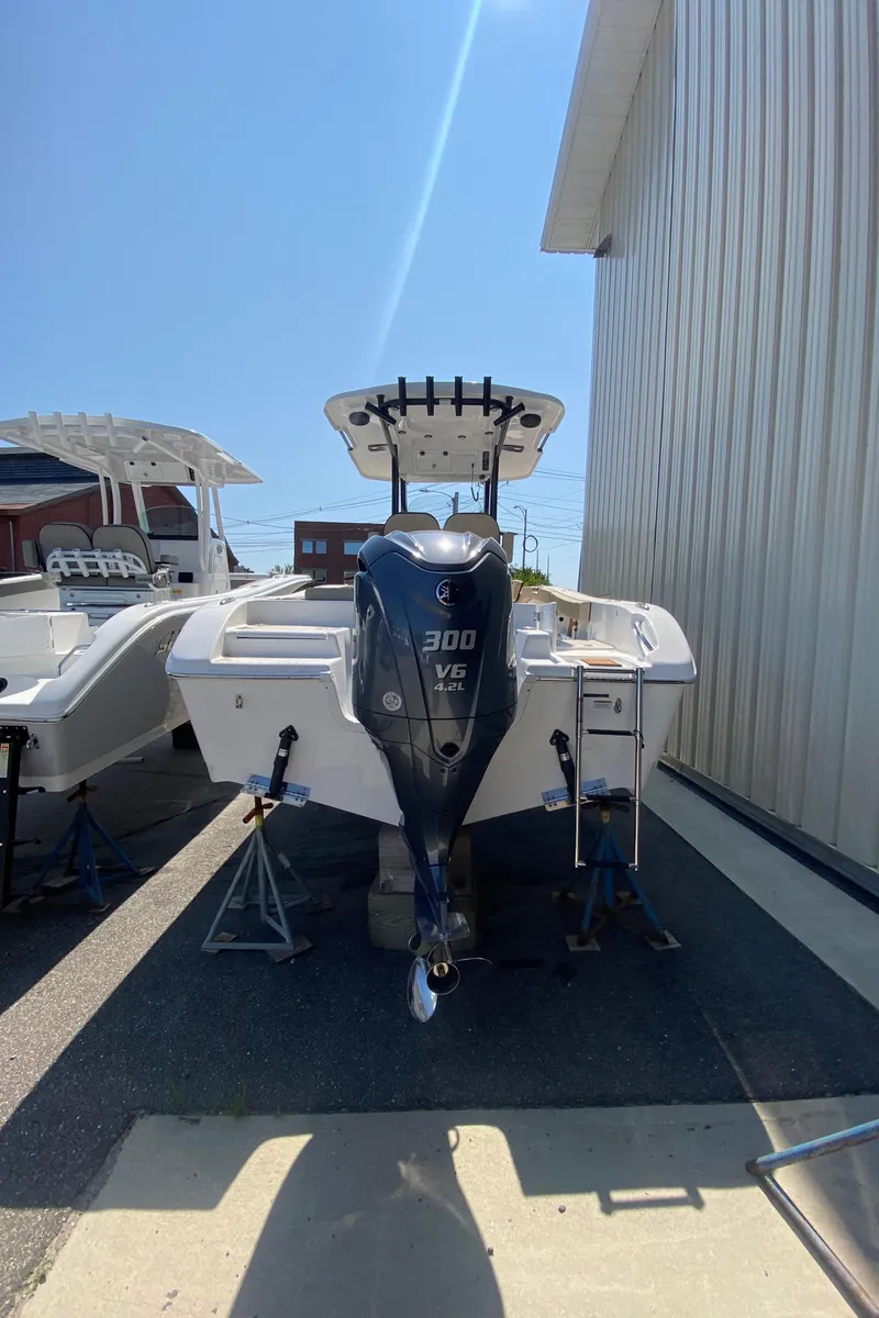 Slide: The Image of 2023 Sea Pro 239 boat with 300 V6 engine, docked outside a warehouse. - 4