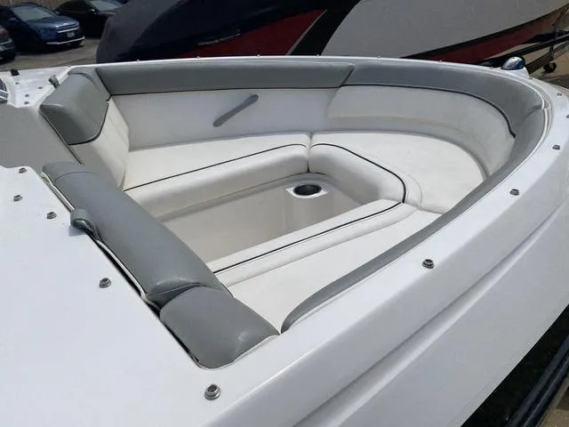 Slide: The Image of 2012 Bayliner 195 Bowrider boat with white and gray cushioned seating. - 7