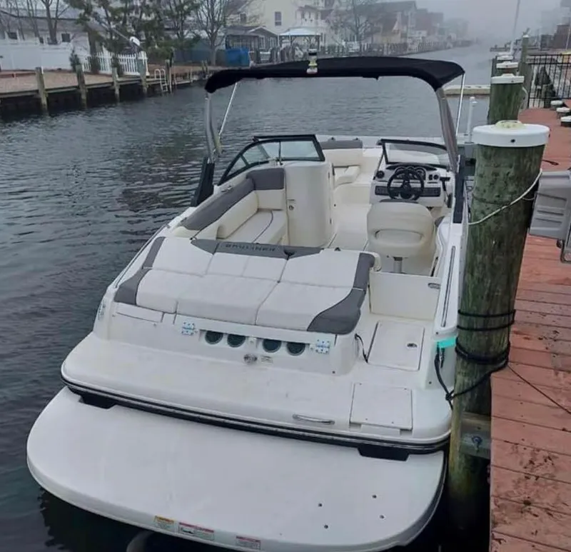 Slide: The Image of 2016 Bayliner 215 Deck Boat docked by a wooden pier on a foggy day. - 10