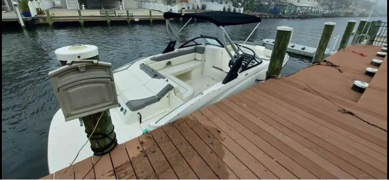 Slide: The Image of 2016 Bayliner 215 Deck Boat docked at a wooden pier. - 15