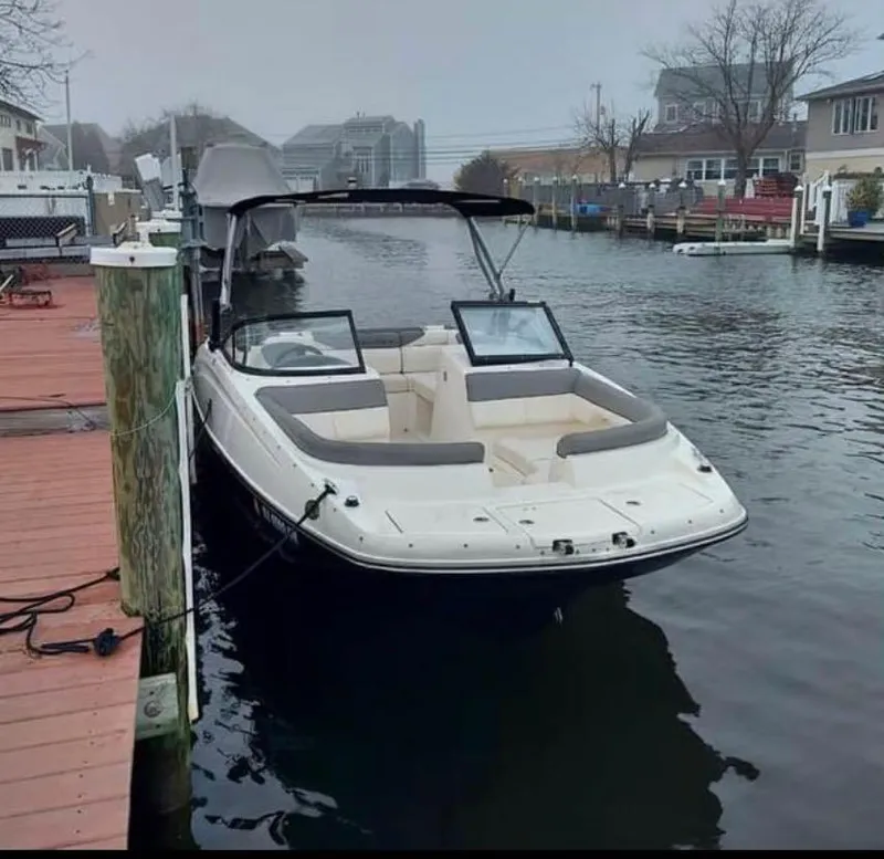 Slide: The Image of 2016 Bayliner 215 Deck Boat docked in a residential canal. - 6