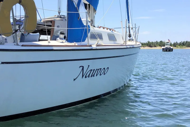 Slide: The Image of 1984 Pearson 34 sailboat "Nauvoo" on calm water with blue sky background. - 1
