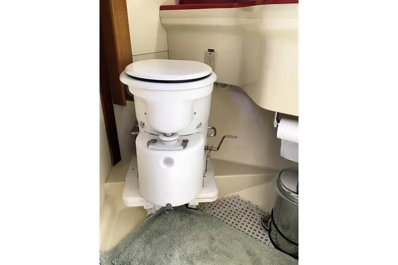 Slide: The Image of Marine toilet in 1984 Pearson 34 sailboat bathroom, featuring compact design and functional layout. - 10