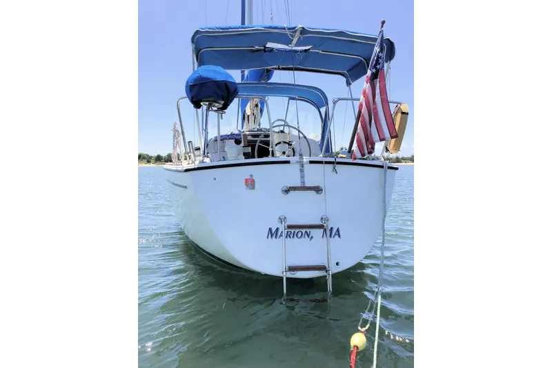 Slide: The Image of 1984 Pearson 34 sailboat with American flag, anchored in calm waters. - 2