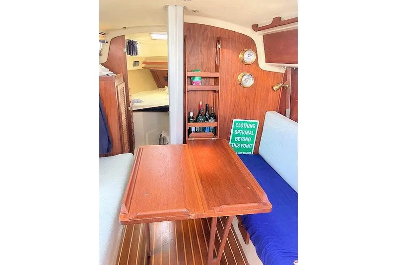 Slide: The Image of Interior of 1984 Pearson 34 sailboat with wooden table and cozy seating area. - 8
