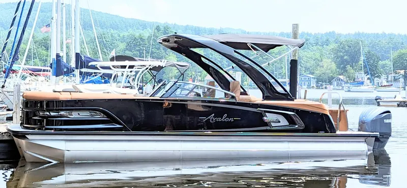 Slide: The Image of 2024 Avalon Excalibur WQL 27 Tri-Toon luxury pontoon boat docked at marina. - 0
