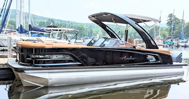 Slide: The Image of 2024 Avalon Excalibur WQL 27 Tri-Toon luxury pontoon boat docked at marina. - 1