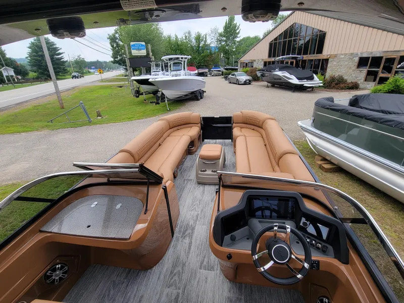 Slide: The Image of 2024 Avalon Excalibur WQL 27 Tri-Toon boat interior with tan seating and modern dashboard. - 11