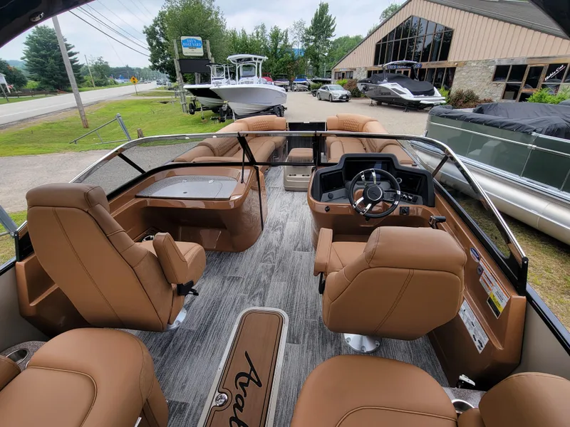Slide: The Image of Interior of 2024 Avalon Excalibur WQL 27 Tri-Toon boat with tan seating and modern dashboard. - 13
